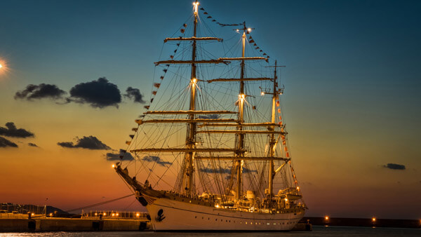 Der historische Dreimaster Mare Frisium bei Sonnenuntergang beleuchtet im Hamburger Hafen liegend