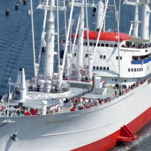 Museumsschiff Cap San Diego bei Fahrt auf der Elbe bei Sonnenschein und mit Menschen an Deck